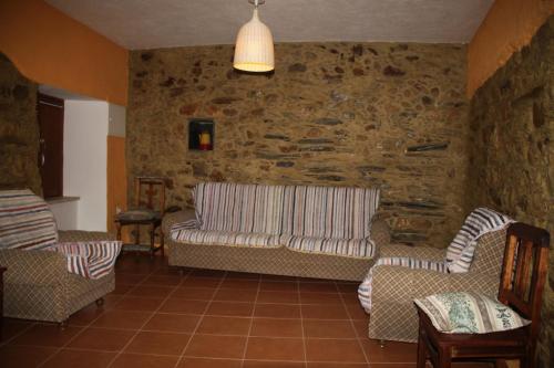 a living room with a couch and two chairs at Casa Do Quelho in Janeiro de Cima