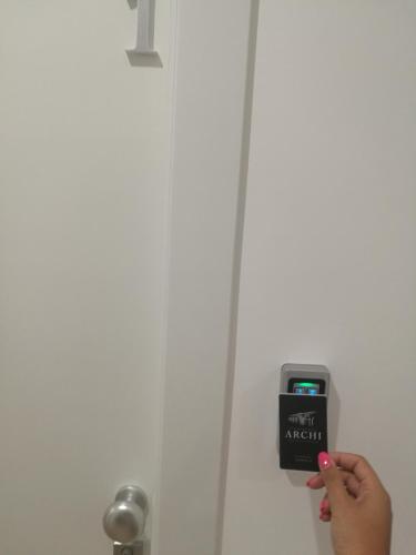 a person holding a smart phone in front of a door at Le Dimore Degli Archi Catania in Catania