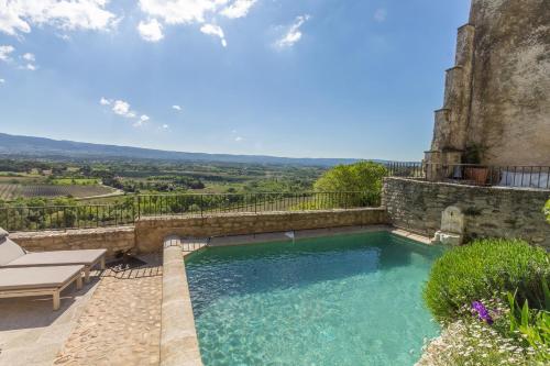 a swimming pool with a table and a bench next to it at Maison Ventoux in Crillon-le-Brave