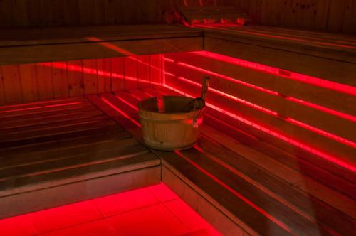 a bucket sitting on a bench in a room with red lights at Dwór Kresowy in Radymno