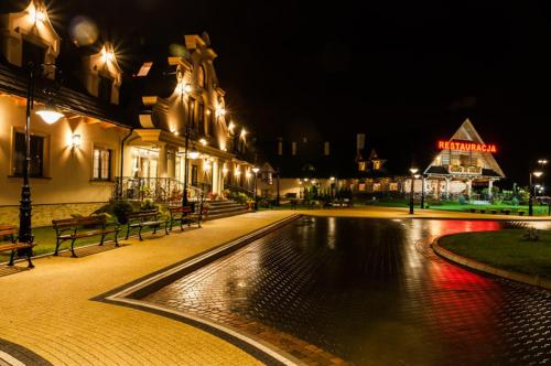 a building with a fountain in a courtyard at night at Dwór Kresowy in Radymno