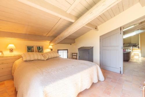 a bedroom with a large bed and a wooden ceiling at Maison Ventoux in Crillon-le-Brave