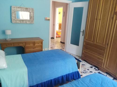 1 dormitorio con 1 cama azul y armario de madera en Casa Rosy, en Montiglio