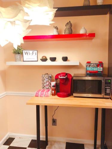a kitchen with a table with a microwave and shelves at 2 Bedrooms Robinwood Condo in Norcross