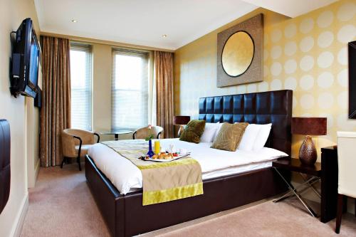 a bedroom with a large bed with a tray of food on it at Washington Mayfair Hotel in London