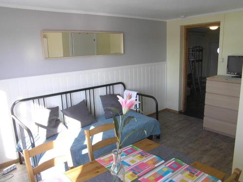a bedroom with a bed and a table with a flower at Bedder at Oslo Airport - serviced apartments in Jessheim