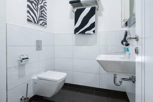 La salle de bains blanche est pourvue de toilettes et d'un lavabo. dans l'établissement High Level Apartment, à Mannheim