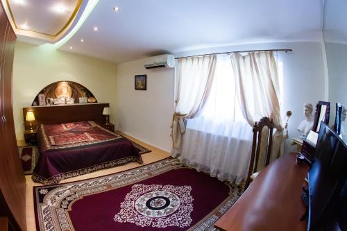 a bedroom with a bed and a window at Hotel Roco in Izvin