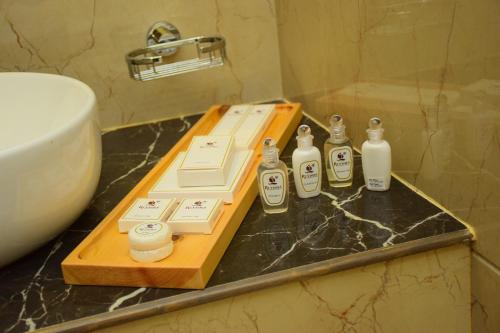 a bathroom counter with bottles of soap and a sink at Ruvisha Beach Hotel in Negombo