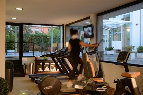 a woman running on a treadmill in a gym at Best Western Hotel Rome Airport in Fiumicino