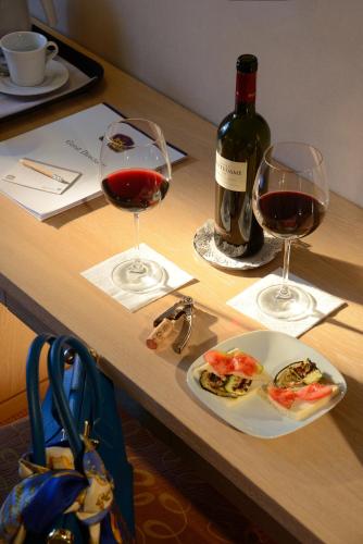 a table with two glasses of wine and a plate of food at Best Western Hotel Rome Airport in Fiumicino