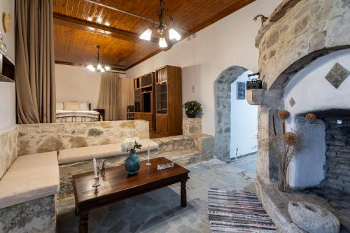 a living room with a couch and a stone fireplace at Villa Tzaniana in Apomarmá