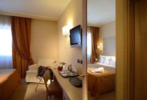 a hotel room with a tv and a bed at Best Western Hotel Rome Airport in Fiumicino