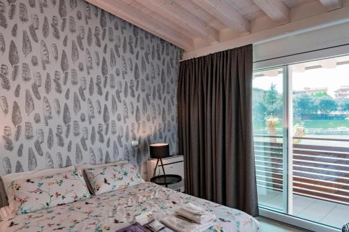 a bedroom with a bed and a wall with bird wallpaper at Alla Riva in Verona