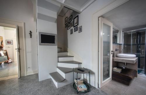 a white bathroom with a staircase and a sink at La Cartapesta in Lecce