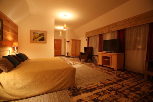 a hotel room with a bed and a flat screen tv at Mecavnik Resort in Mokra Gora