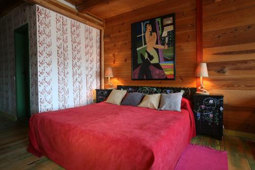 a bedroom with a red bed in a wooden room at Mecavnik Resort in Mokra Gora