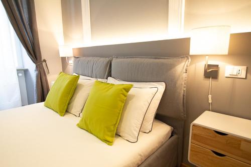 a bedroom with a bed with yellow pillows at Maison Amelie in Trieste