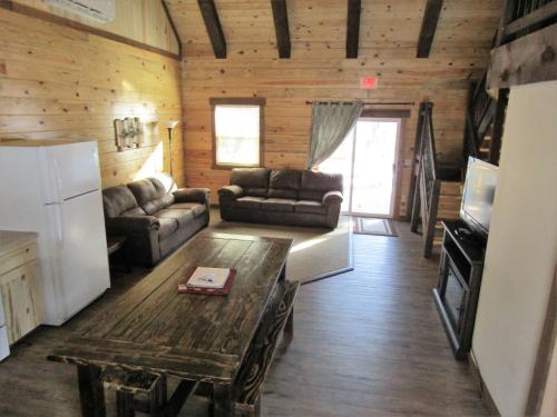 a living room with a couch and a table at Freedom Ridge Cabins in Hill City