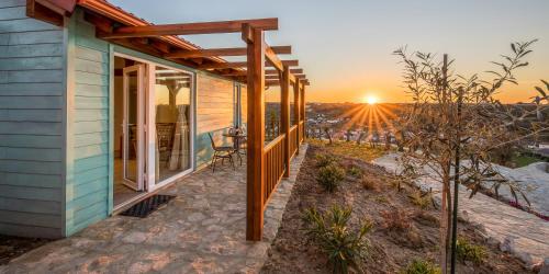 a house with the sunset in the background at The Olive Hill Guesthouse in Batalha