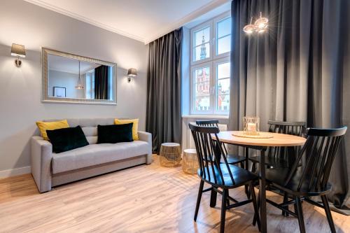 een woonkamer met een bank en een tafel bij Dom & House - Apartments Old Town Ogarna in Gdańsk