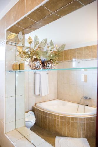 a bathroom with a tub and a toilet at Hotel Roco in Izvin