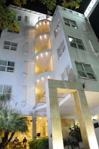 a white building with a spiral staircase in front of it at Parra Hotel & Suites in Rafaela