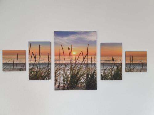 a sunset over the beach with tall grass canvas wall art at Ferienwohnung Muldental in Grimma