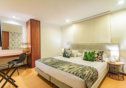 ein Hotelzimmer mit einem Bett und einem Schreibtisch in der Unterkunft Hotel Factory Green Bogotá in Bogotá