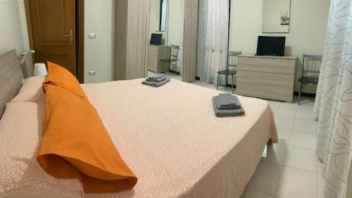 - une chambre avec un grand lit et des oreillers orange dans l'établissement 32, à Ciampino
