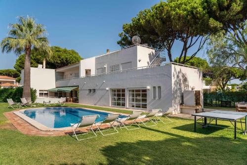 a house with a pool and chairs and a table at Luxury Villa 6 bedrooms with private pool in Vilamoura