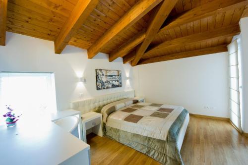 una camera con letto in una stanza con soffitti in legno di Jolie Bed And Breakfast a Pescara