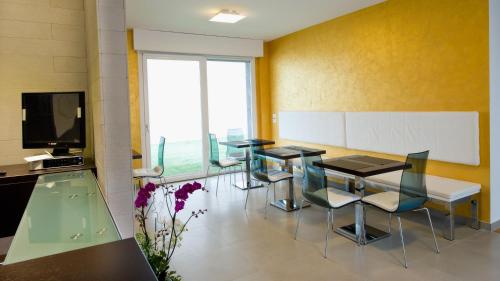 a dining room with tables and chairs and a tv at Jolie Bed And Breakfast in Pescara