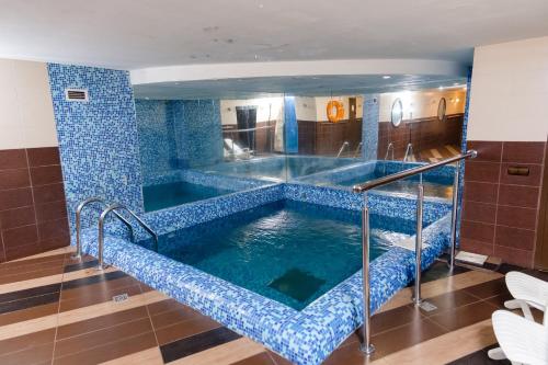 Una piscina de agua en un baño con azulejos azules en Aurooms, en Novokuznetsk