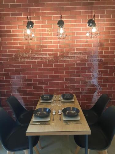 a wooden table with black chairs and a brick wall at Volos Center Luxury Home in Volos