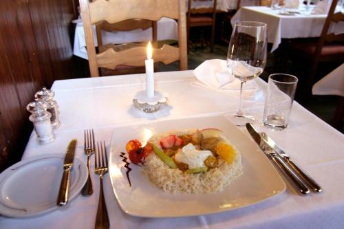 a plate of food on a table with a candle at Hotel Eremitage in Arlesheim