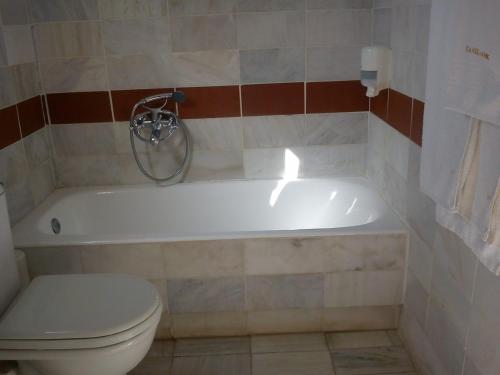 a bathroom with a toilet and a white bath tub at Panselinos Hotel in Mithymna