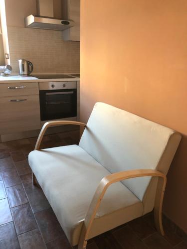a white chair in a room with a kitchen at Le case di Nonna Gina in Capranica