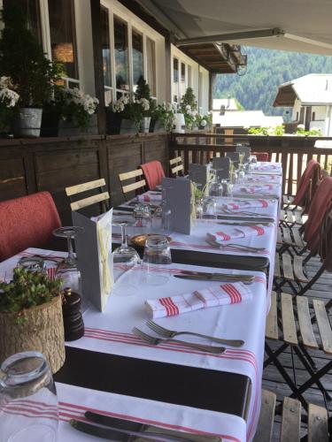 een lange tafel voor een maaltijd op een patio bij Hôtel Le Grand Chalet Favre in Saint-Luc