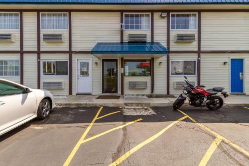a motorcycle parked in a parking lot in front of a building at Motel 6-Rossford, OH in Rossford