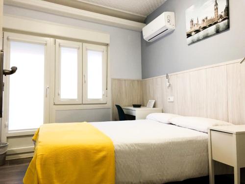 Un dormitorio con una cama con una manta amarilla. en Alojamiento HC, en Colmenar Viejo