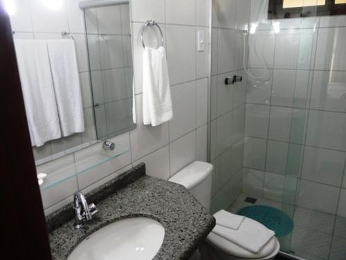 uma casa de banho com um WC, um lavatório e um chuveiro em Pousada Calugi em Triunfo