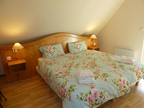 a bedroom with a large bed with flowers on it at Les cerisiers in Bernardswiller