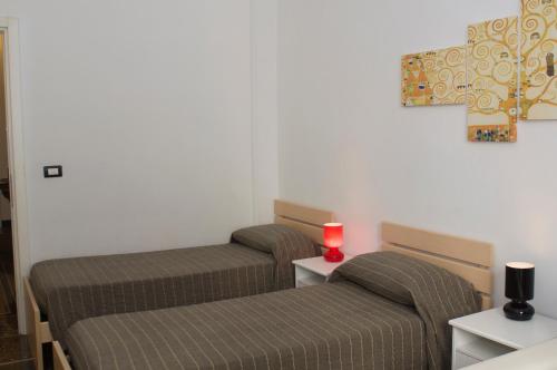 2 posti letto in una camera con una candela rossa su un tavolo di Perdiana House a Genova