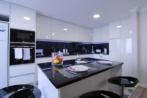 a kitchen with white cabinets and a black counter top at Casa Cervo Artes in Vila Nova de Cerveira