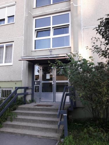 einen Eingang zu einem Gebäude mit einer Glastür in der Unterkunft Stúdió+19 Apartman in Kazincbarcika