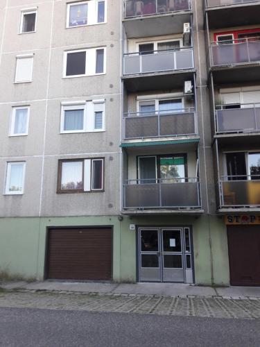 ein Apartmenthaus mit zwei Garagentüren und Fenstern in der Unterkunft Stúdió+19 Apartman in Kazincbarcika
