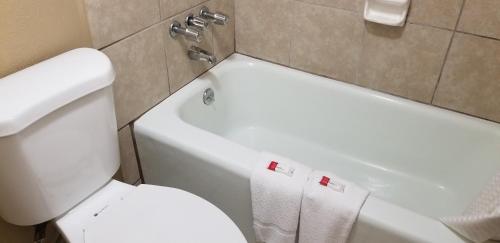 a bathroom with a white toilet and a sink at Days Inn by Wyndham Cocoa Cruiseport West At I-95/524 in Cocoa