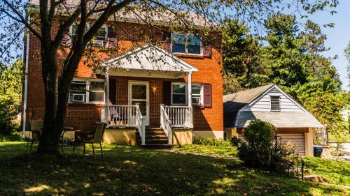 a red brick house with a porch and a tree at Red brick house in Chalfont