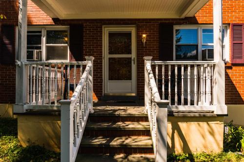 a front porch of a house with a white railing at Red brick house in Chalfont